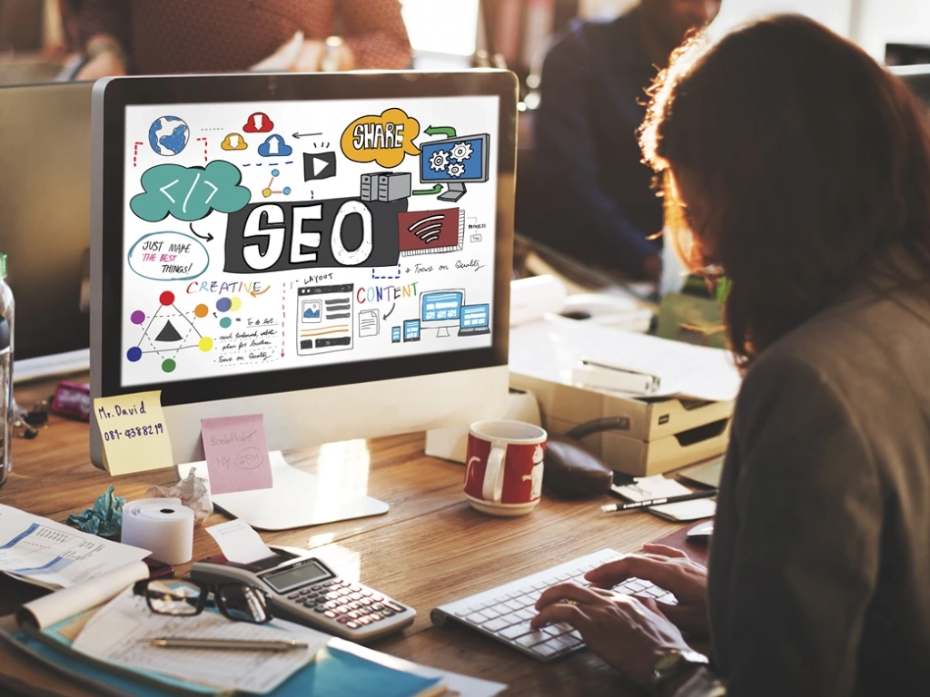 Woman looking at SEO strategies on a monitor, researching how to advertise a timeshare for sale.