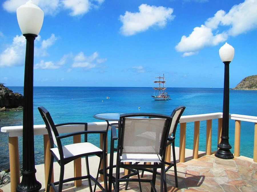 Oceanfront terrace at Divi Little Bay Beach Resort with outdoor dining seating and a tall ship sailing in the deep blue Caribbean Sea.

How does Divi Resorts timeshare work?