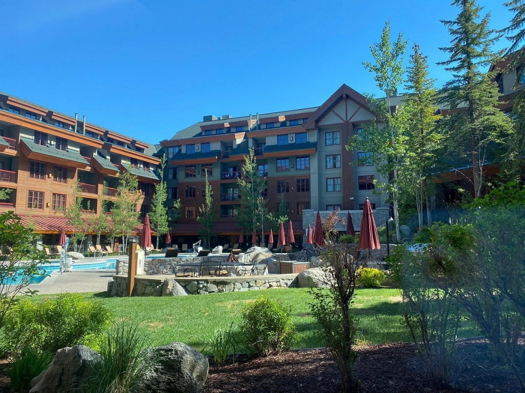 A luxury Lake Tahoe timeshare featuring a large outdoor pool and courtyard surrounded by forest.