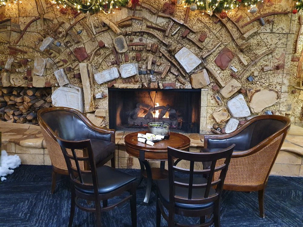 A cozy lounge area with leather chairs in front of a unique mosaic stone fireplace at a Lake Tahoe timeshare.