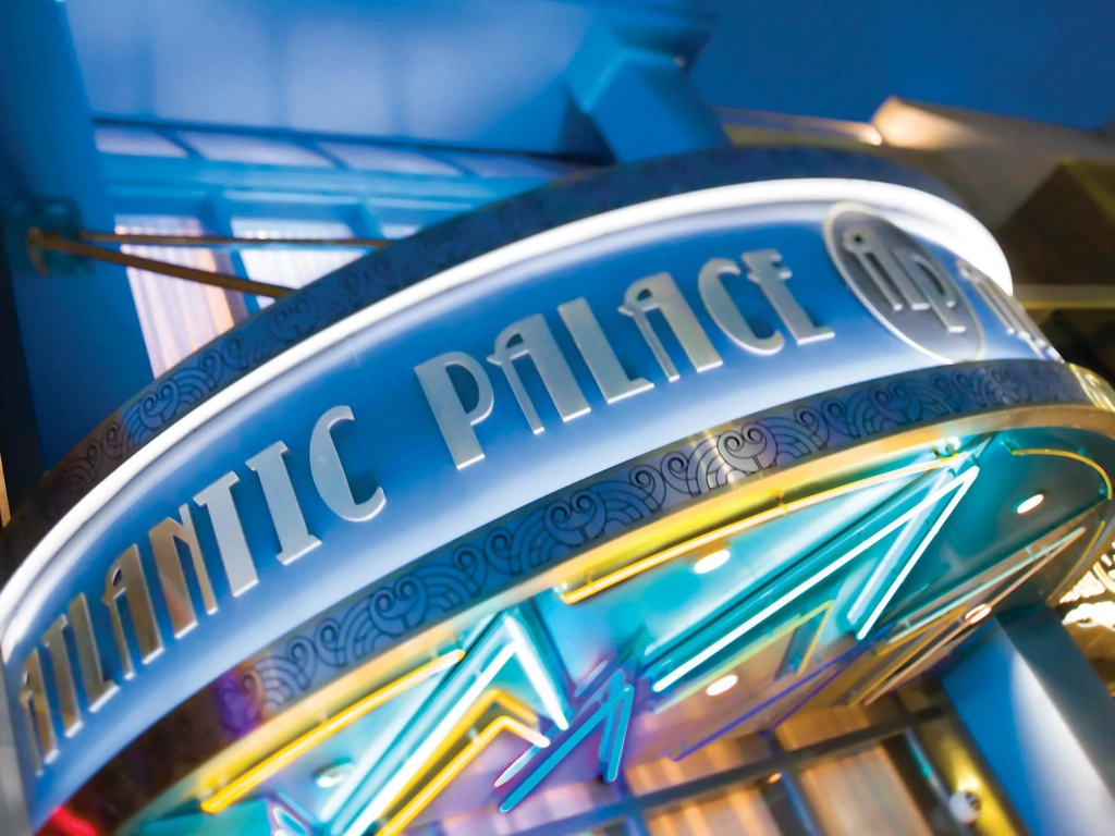 Illuminated neon marquee of Atlantic Palace, a resort featured in positive bluegreen vacations reviews.