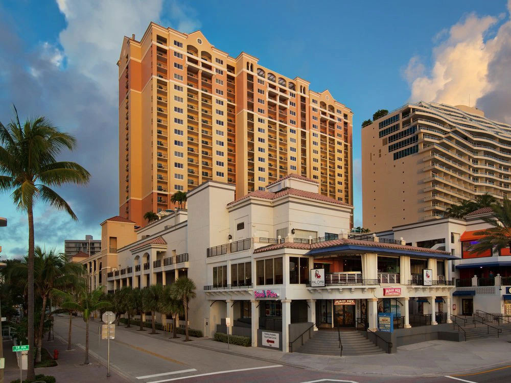 Exterior view of Marriott's BeachPlace Towers towering above beachfront shops in Fort Lauderdale, Florida.