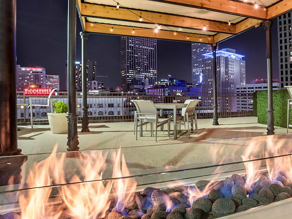 Rooftop patio with a burning fire pit and city skyline views at night at The Marquee resort.