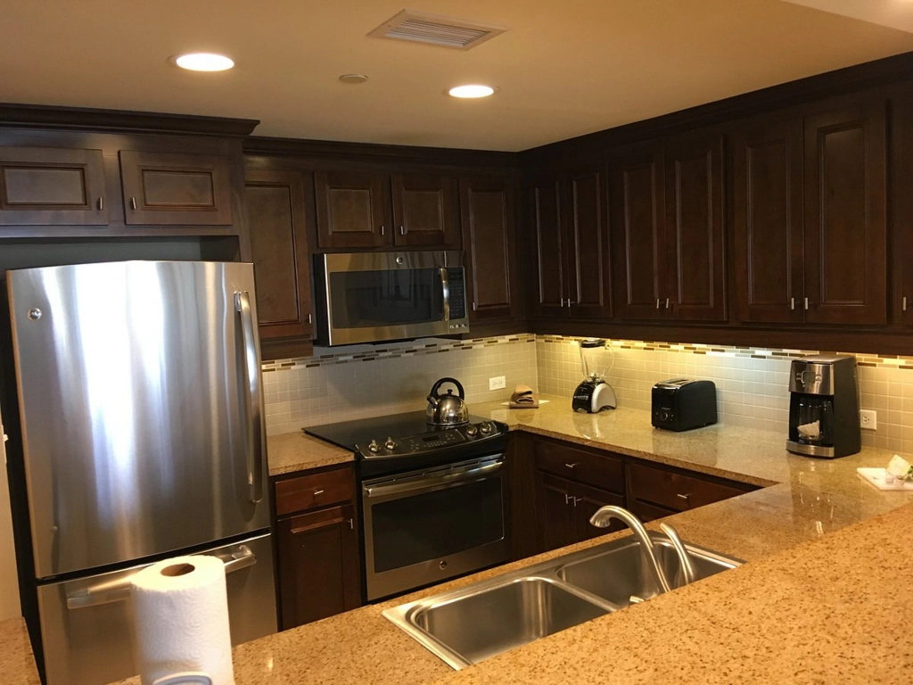 A well-equipped kitchen featuring dark wood cabinets, granite countertops, and stainless steel appliances.