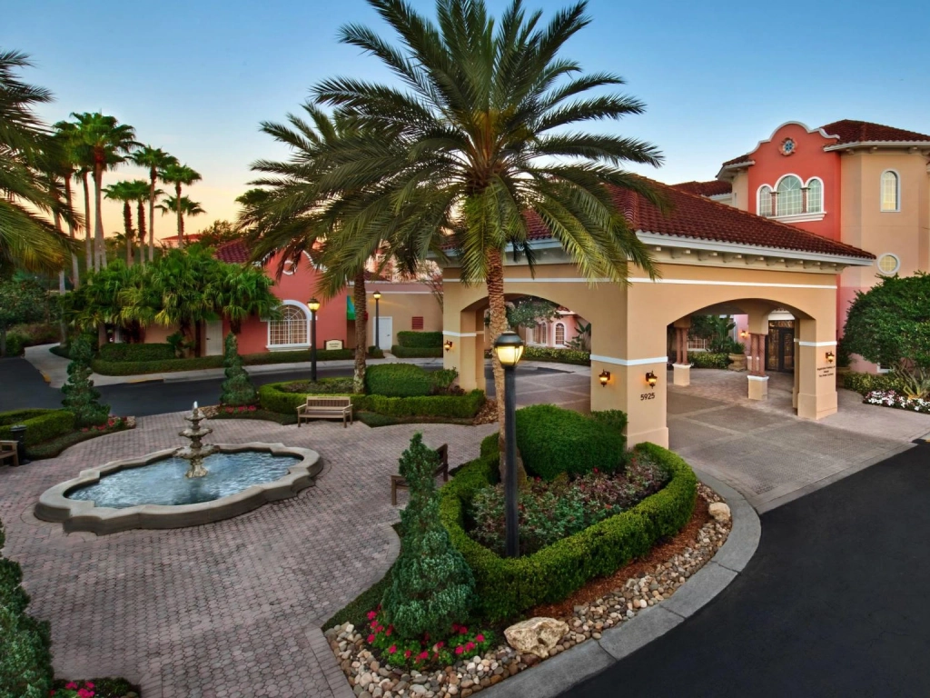 Covered entryway, fountain, and pink exterior of Marriott's Grande Vista resort.
