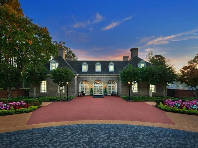 Brick colonial-style building and red pathway at sunset at Marriott's Manor Club at Ford's Colony.