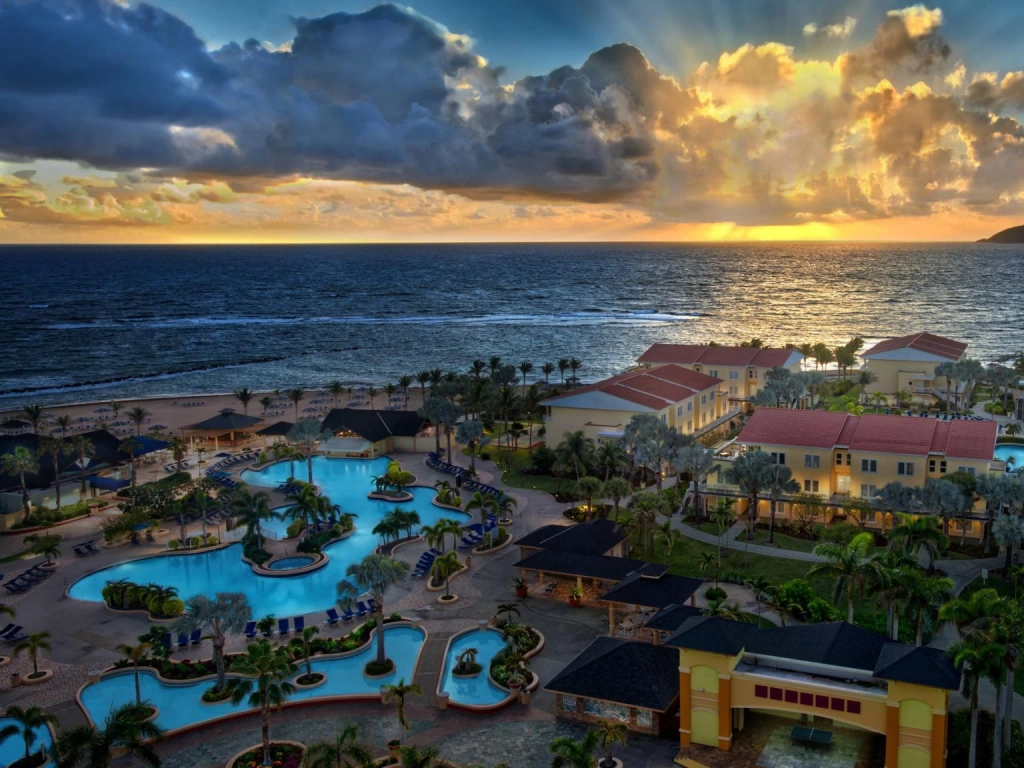 Sunset over the ocean, winding pools, and yellow buildings at Marriott's St. Kitts Beach Club.